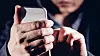 Hooded cyber crime hacker using mobile phone internet hacking in to cyberspace,online personal data security concept.
