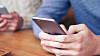 Cropped shot of people holding phone and texting