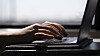 FILE - This May 18, 2021, photo shows a woman typing on a laptop on a train in New Jersey. Scams ar ...