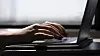 FILE - This May 18, 2021, photo shows a woman typing on a laptop on a train in New Jersey. Scams ar ...