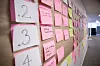 Enkelte steder er veggene tapetsert med postit-lapper. Disse illustrerer blant annet progresjon, oppgaver som må gjøres og ideer til funksjonalitet. Foto: Erlend Tangeraas Lygre