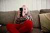 Inne på hytta kan det friste å være litt på mobilen. Foto: NTB