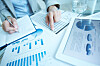 Hands of businesswoman writing down financial data in notepad