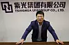 Styreformann Zhao i Tsinghua Unigroup poserer foran selskapets logo under søndagens intervju med Reuters i Beijing. Teknologiselskapet springer ut fra eliteuniversitetet med samme navn, der blant annet Kinas president Xi Jinping har sin utdannelse fra.
