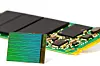 3D-NAND-brikke fra Intel og Micron med en M.2-SSD i bakgrunnen.