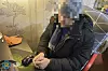 Den ukrainske hackeren som har blitt påført håndjern. I bakgrunnen ser man det som trolig er et fuglebur. Foto: Sluzhba bezpeky Ukrayiny