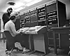De to sentrale Unix-oppfinnerne, Dennis Ritchie (stående) og Ken Thompson, foran minidatamaskinen DEC PDP-11 og kabinetter med en hel del annet utstyr. Bildet er trolig tatt i 1972. Foto: Bell Labs