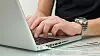 Businessman typing on a notebook (shallow DOF, hand in focus)
