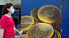 En kvinne passerer reklame for kryptovalutaen bitcoin i Hongkong. Utvinning av bitcoin krever enorme mengder energi er og er businessen er blitt en miljøversting.