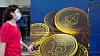 En kvinne passerer reklame for kryptovalutaen bitcoin i Hongkong. Utvinning av bitcoin krever enorme mengder energi er og er businessen er blitt en miljøversting.