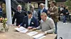 Senioringeniør Håkon Eyde Kjuus i Forsvarsmateriell og administrerende direktør Eivind Helgaker i Ice signerer samarbeidsavtale under påsyn av fornøyde medarbeidere fra Ice og Forsvarsmateriell.