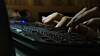 fingers of female on laptop, working late at night, blank blurred white screen as background, dark tone