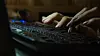 fingers of female on laptop, working late at night, blank blurred white screen as background, dark tone