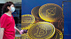 En kvinne går forbi en Bitcoin-reklame i Hongkong.
