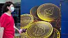En kvinne går forbi en Bitcoin-reklame i Hongkong.