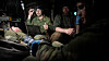 Combat medic Tinius Fjærn prøver å redde en såret soldat med en lege på øyet, mens opplæringsansvarlig i Bliksund, Otto Andre Haaland, assisterer ved siden av. I forgrunnen jobber medic Lars Olav Joa med pasienten.