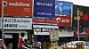 Reklamen i denne gaten i Mumbai gjenspeiler den harde konkurransen i Indias mobilmarked, mellom blant annet Vodafone, Reliance, Uninor, Airtel og Tata Docomo. Gjennomføres nye auksjoner på mobillisenser står flere utenlandske aktører i fare for milliardtap.