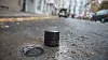 BAKKESENSOR: Disse sensorene skal gjøre 300 parkeringsplasser i Oslo smarte. Bildet viser to sensorer: En er allerede montert i bakken, mens den andre venter på å komme ned i asfalten. Foto: Mathias Klingenberg