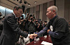 Hwang Sang-gi (til høyre) hilser på Samsung-toppen Kinam Kim. Hwang Sang-gi er faren til fabrikkarbeideren Hwang Yu-mi som døde av kreft i 2007 for å ha jobbet for Samsung.