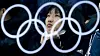 Illustrasjonsbilde: De olympiske ringene reflektert i et glass. En kvinnelig tilskuer sitter bak glasset og ser på mixed double-semifinalen i curling mellom Canada og Norge under de olympiske vinterlekene i Pyeongchang, Sør-Korea.