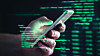 Darkweb, darknet and hacking concept. Hacker with cellphone. Man using dark web with smartphone. Mobile phone fraud, online scam and cyber security threat. Scammer using stolen cell. AR data code.