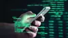 Darkweb, darknet and hacking concept. Hacker with cellphone. Man using dark web with smartphone. Mobile phone fraud, online scam and cyber security threat. Scammer using stolen cell. AR data code.