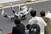 Det er ikke bare-bare å stokke beina riktig. En annen robot måtte bæres bort på båre. Foto: Iori Sagisawa/Kyodo News/AP/NTB