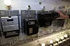 Innen utgangen av 2018 skal alle norske hjem få digital strømmåler, en AMS-boks som vi ser til venstre i bildet. Her har Hafslund hengt opp også noen eldgamle strømmålere, blant annet en tysk variant med myntinnkast. Foto: Marius Jørgenrud