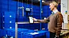 Roboten som henger foran Arnor Jonasson finner lett fram i kassene som utgjør robotlagersystemet til Blue Robot. Utviklingen av styringssystemet og -algoritmene til roboten gjør selskapet ser på seg selv som en softwarebedrift.