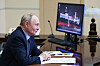 Vladimir Putin ved et stort skrivebord med en dataskjerm.