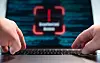 Finger typting on the laptop keyboard, blurred warning sign unauthorized access on the screen, computer crime. Hacker, data, code, encryption, data breach, spyware, communication problems, computer language, security, firewall.